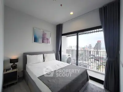 Modern bedroom with city view and balcony access in a high-rise apartment.