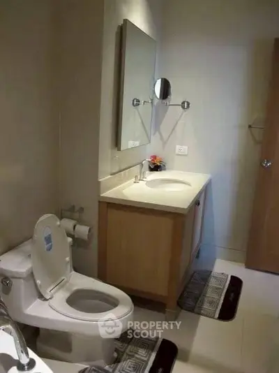 Modern bathroom with sleek vanity and toilet, featuring elegant fixtures and a minimalist design.