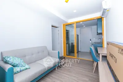 Modern apartment living room with sleek design and open kitchen layout.