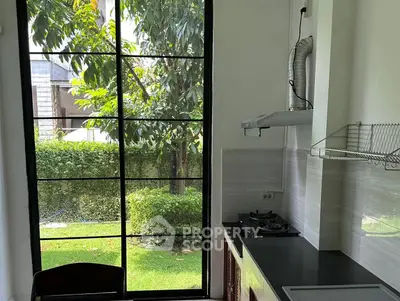 Modern kitchen with garden view and sleek black countertops
