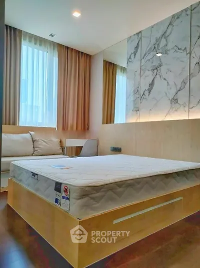 Modern bedroom with stylish decor and natural light, featuring a comfortable bed and elegant furnishings.