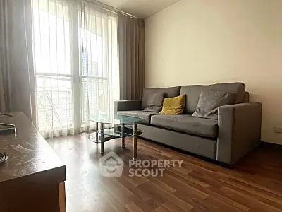 Modern living room with large windows and stylish furniture in a high-rise apartment.