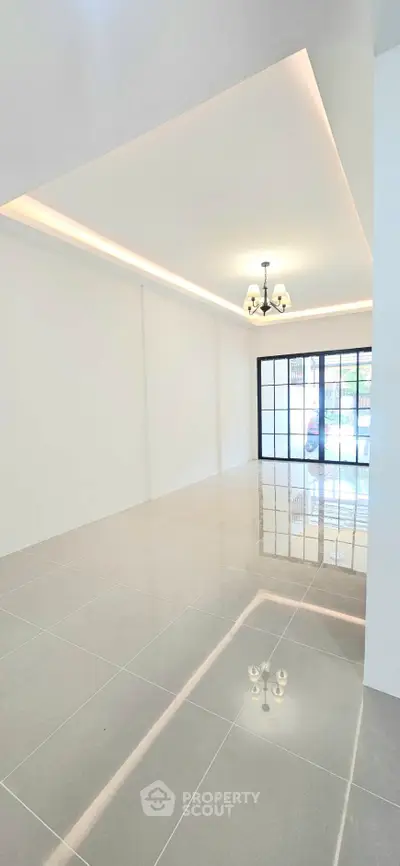 Spacious modern living room with elegant lighting and large windows for natural light.