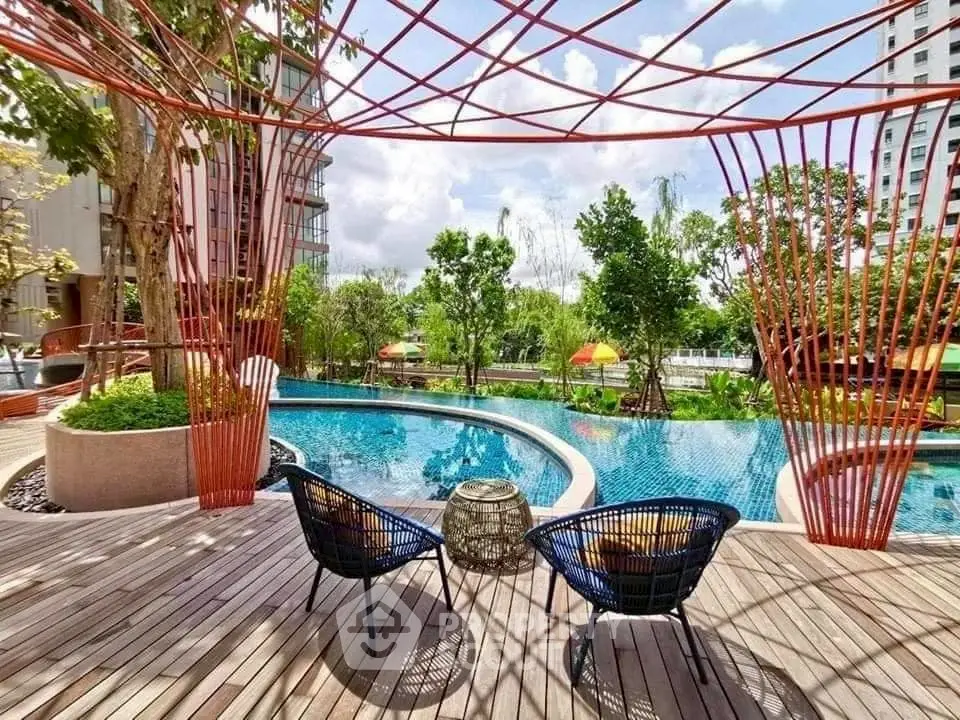 Luxurious poolside area with modern seating and lush greenery, perfect for relaxation and leisure.
