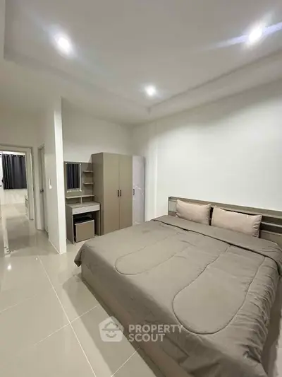 Modern bedroom with sleek design and neutral tones, featuring a comfortable bed and ample storage space.