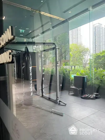 Modern gym with punching bags and fitness equipment in luxury apartment complex