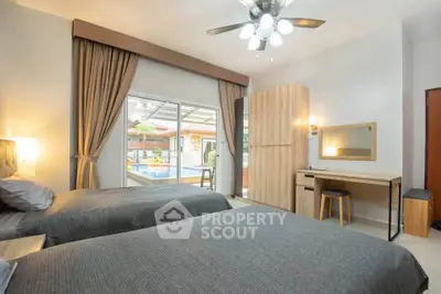 Spacious bedroom with pool view, modern decor, and ample natural light.