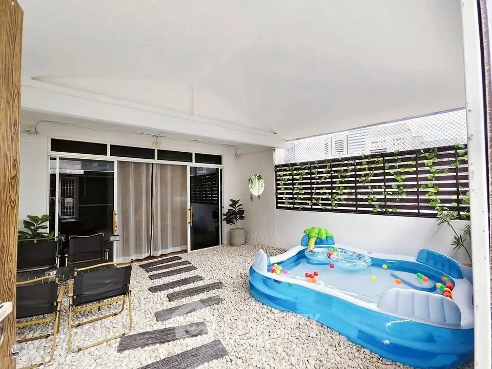 Charming outdoor patio with inflatable pool and seating area, perfect for relaxation and family fun.