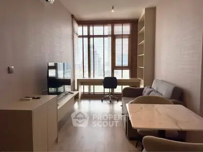 Modern living room with sleek furniture and large windows offering city views.