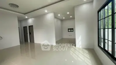 Spacious modern living room with glossy tiled floors and large windows for natural light.