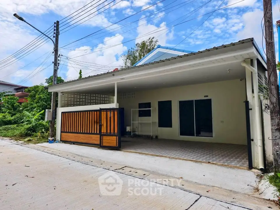 Charming single-story home with spacious carport and modern gate in a serene neighborhood.