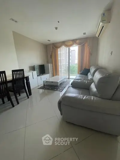 Spacious living room with modern furniture and large window view