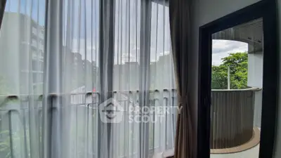 Spacious balcony view with sheer curtains in modern apartment