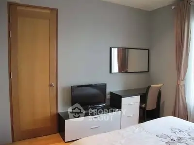 Cozy bedroom with TV and desk, perfect for relaxation and work.