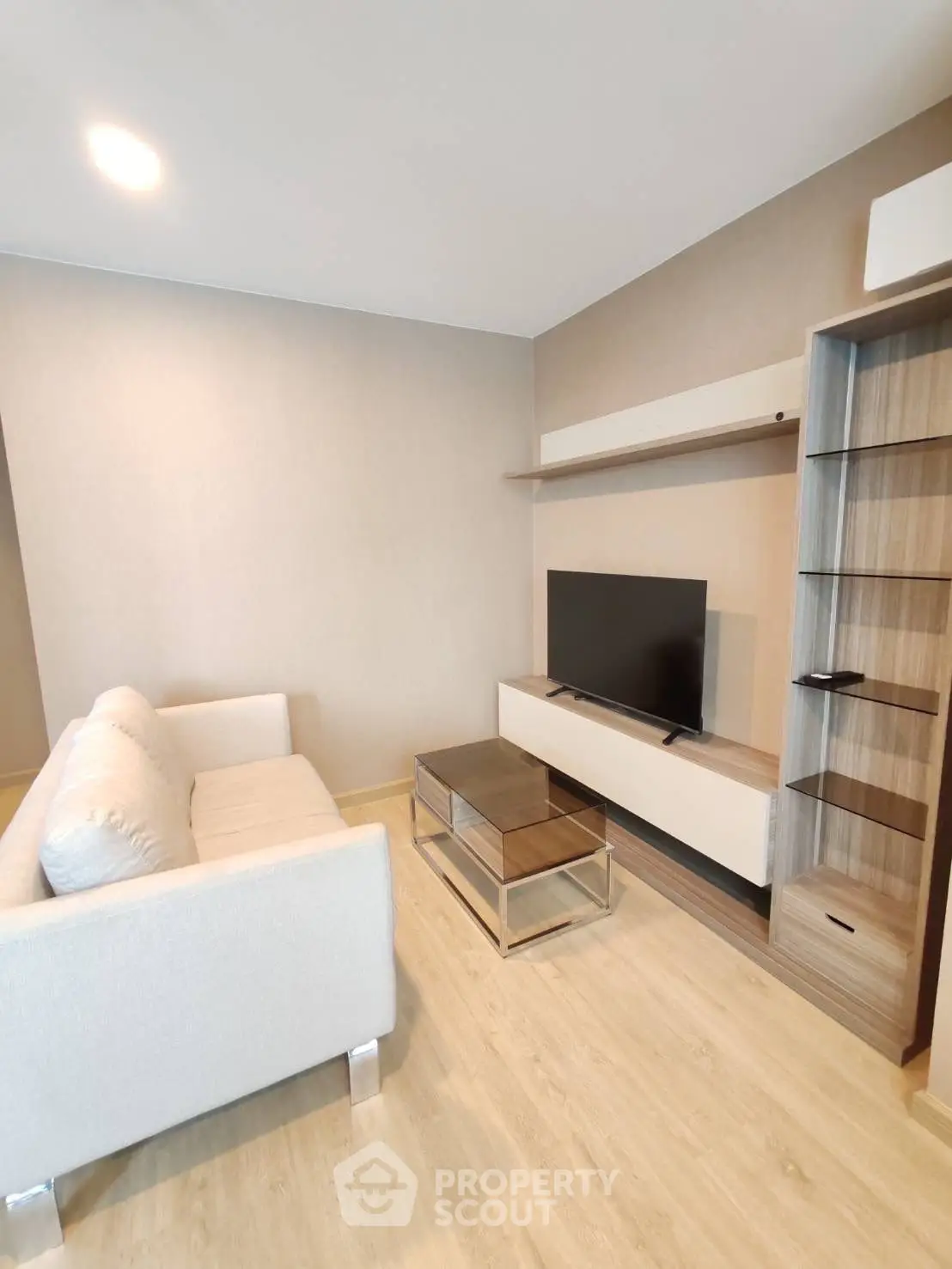 Modern living room with sleek furniture and mounted TV, perfect for relaxation.