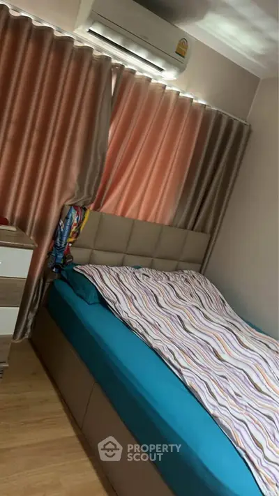 Cozy bedroom with modern decor and air conditioning, featuring a comfortable bed and stylish curtains.