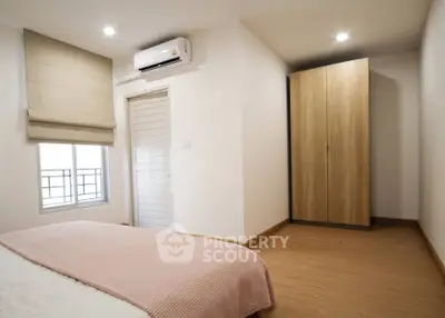 Spacious bedroom with modern air conditioning and ample natural light.
