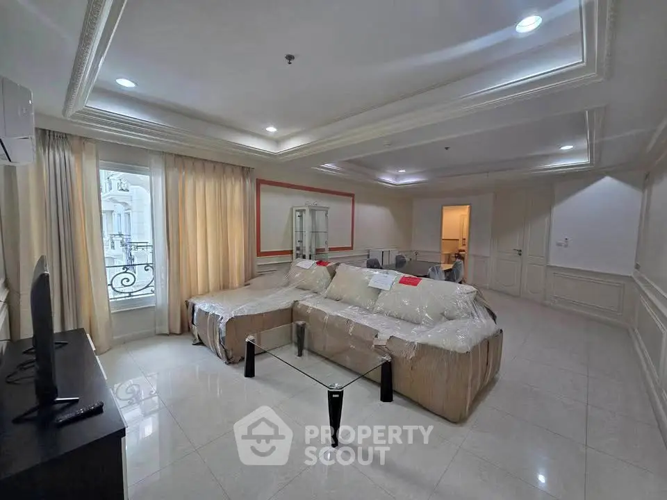 Spacious living room with elegant decor and large windows in luxury apartment.