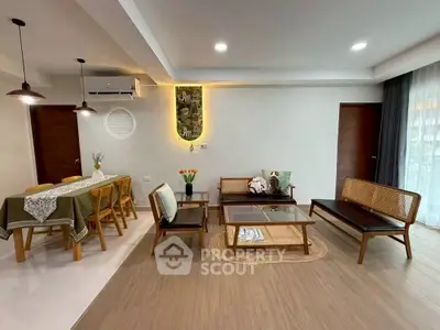 Modern living room with stylish furniture and dining area, featuring elegant lighting and decor.