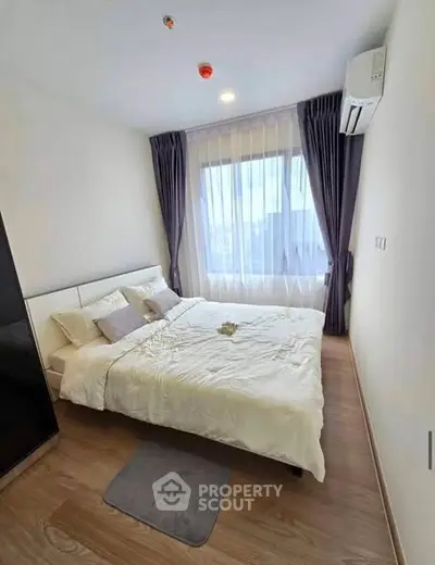 Modern bedroom with large window and elegant curtains in a stylish apartment.