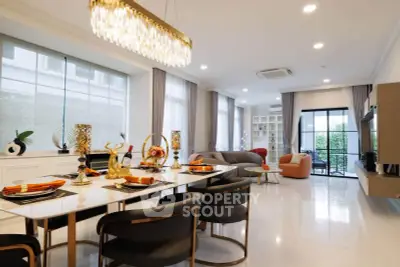 Luxurious open-plan living and dining area with elegant decor and large windows.