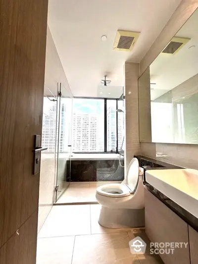 Modern bathroom with city view, featuring glass shower and sleek design.