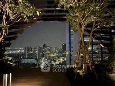Stunning rooftop view of city skyline at night with modern architecture and lush greenery.