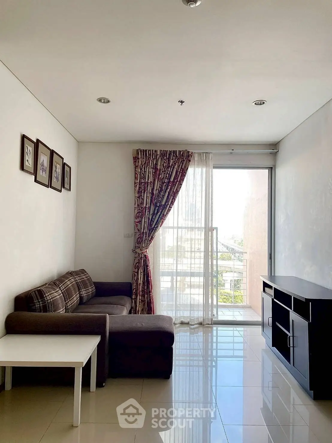Bright living room with modern sofa, elegant curtains, and large window offering natural light.