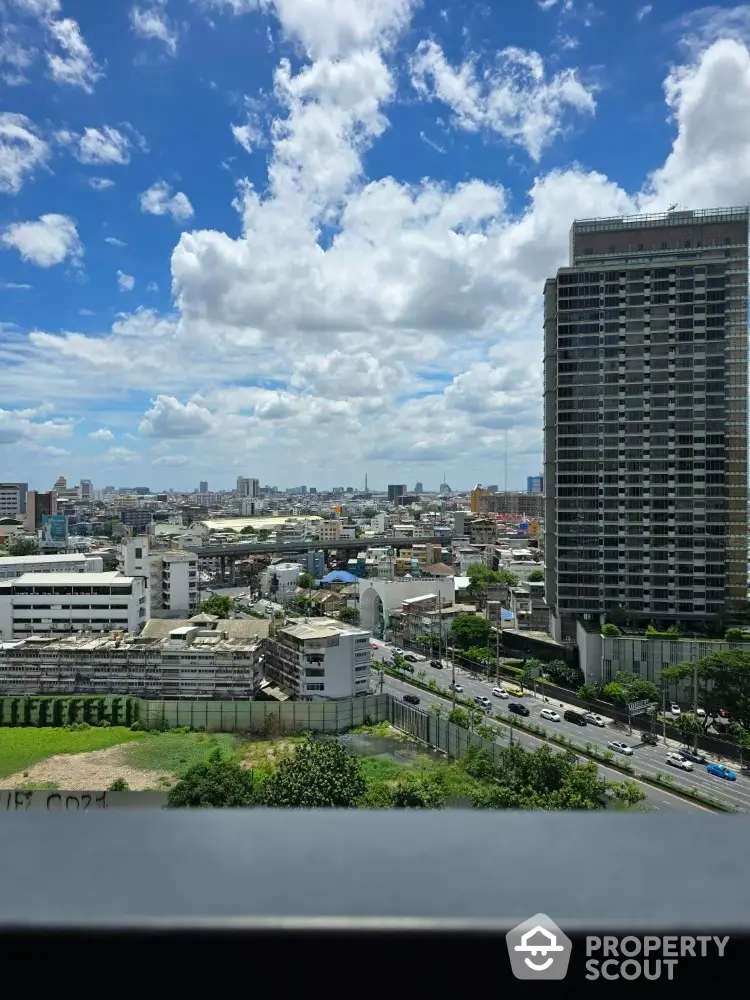 Stunning cityscape view from high-rise building with clear blue sky and urban skyline.