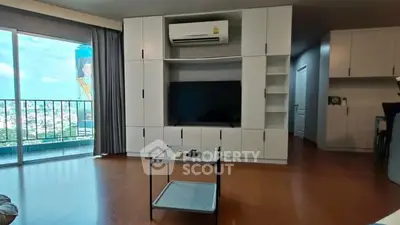 Spacious living room with modern entertainment center and balcony view