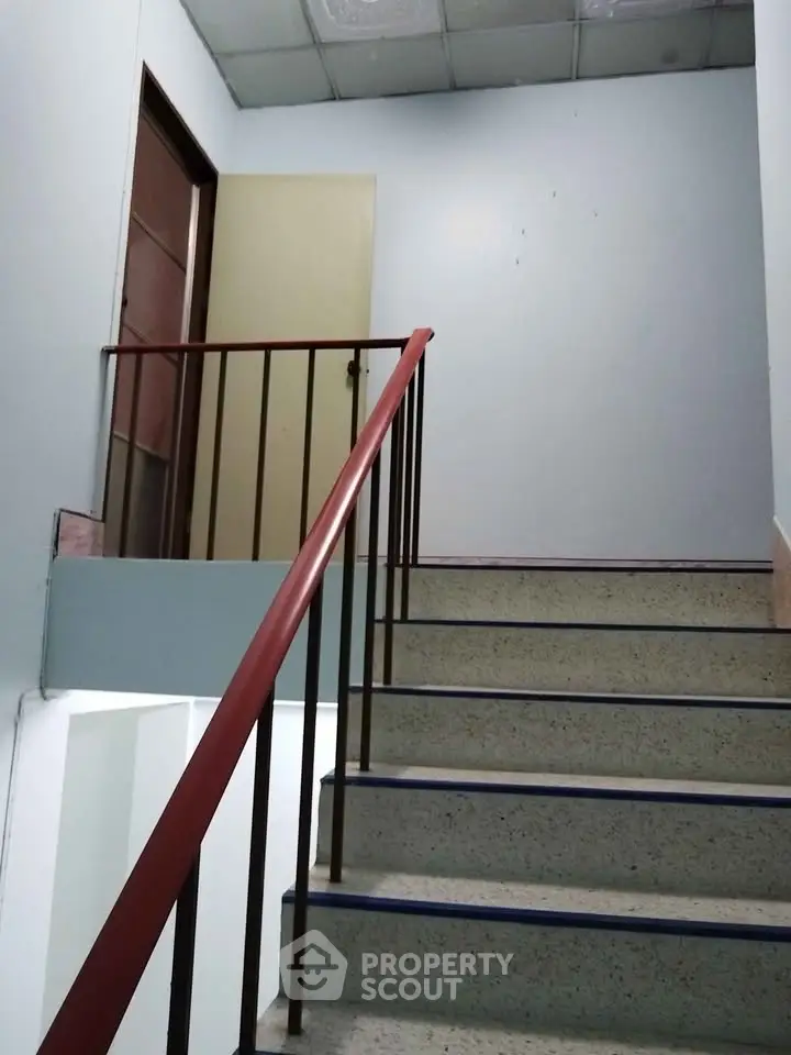 Staircase in a residential building with simple design and metal railing.