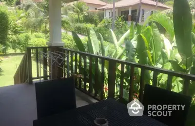 Charming tropical balcony with lush greenery and cozy seating area