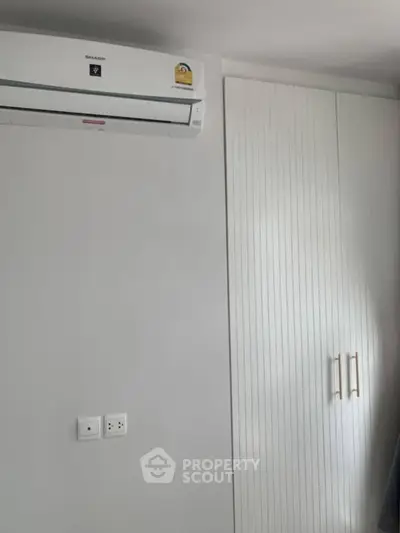 Modern bedroom with sleek air conditioning and built-in wardrobe