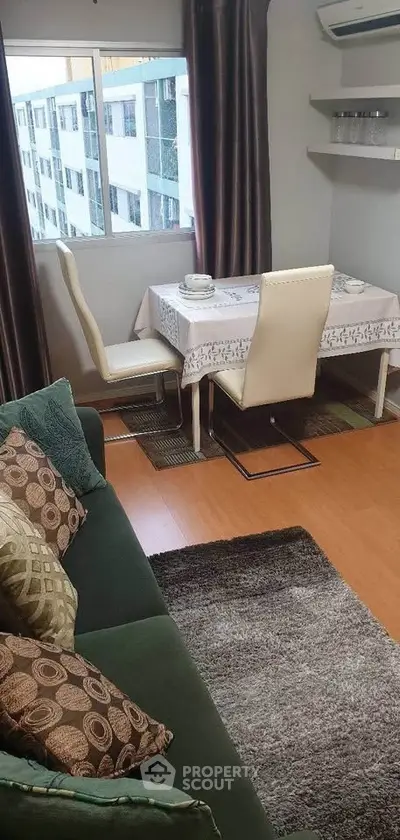 Cozy living room with dining area, featuring elegant decor and large window with city view.