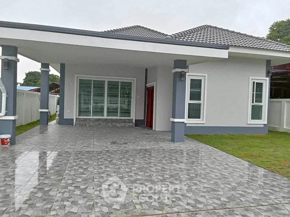 Modern single-story house with tiled driveway and spacious front yard.