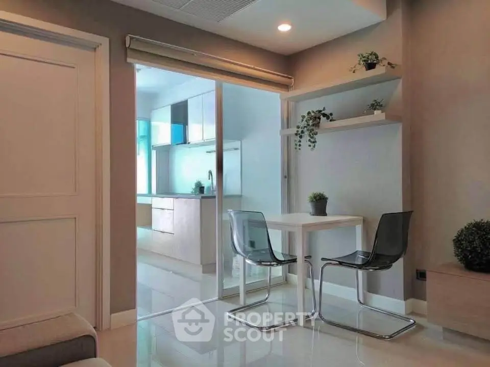 Modern dining area with glass partition and sleek kitchen view