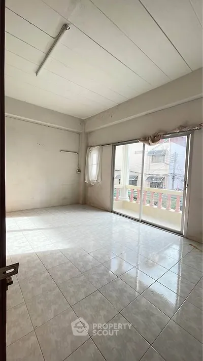 Spacious unfurnished room with large windows and balcony access, ideal for customization.