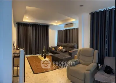 Spacious living room with modern furniture and elegant lighting, perfect for relaxation and entertainment.