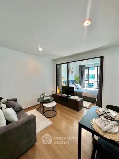 Modern living room with cozy decor and view into stylish bedroom