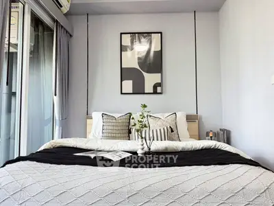 Modern bedroom with stylish decor and balcony access in a contemporary apartment.