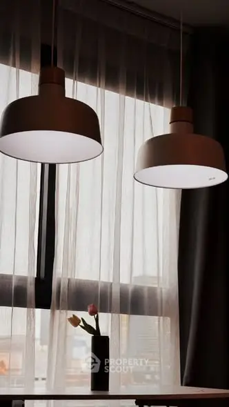 Elegant dining area with modern pendant lights and city view through sheer curtains.