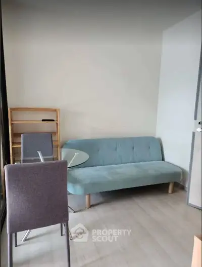 Cozy living room with modern sofa and dining table, perfect for small spaces.