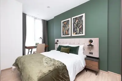Stylish bedroom with green accent wall and modern decor