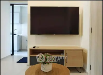 Modern living room with wall-mounted TV and stylish wooden furniture, perfect for cozy entertainment.