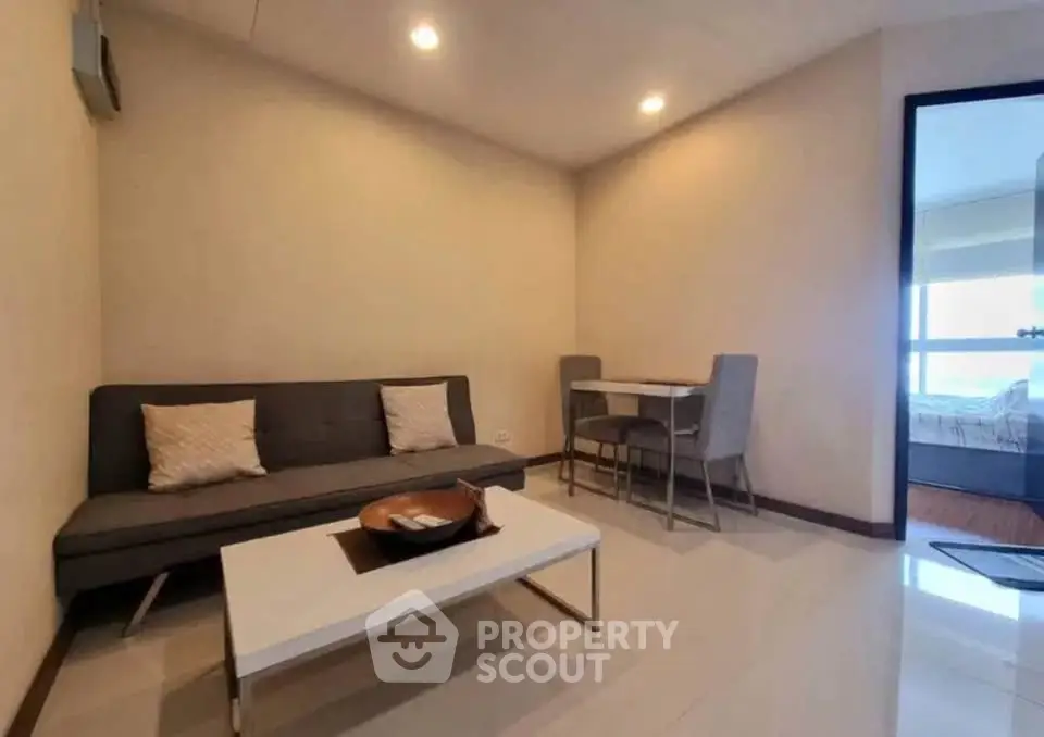 Modern living room with sleek furniture and dining area in a cozy apartment.