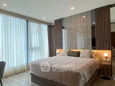 Luxurious modern bedroom with elegant decor and large windows for natural light.