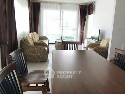 Spacious living room with elegant wicker furniture and large windows for natural light.