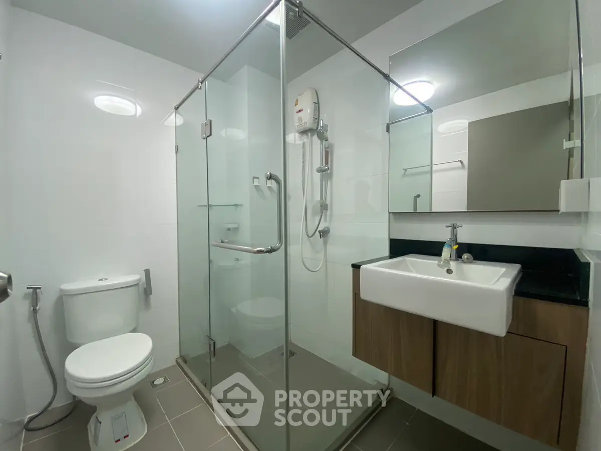 Modern bathroom with glass shower enclosure and sleek fixtures