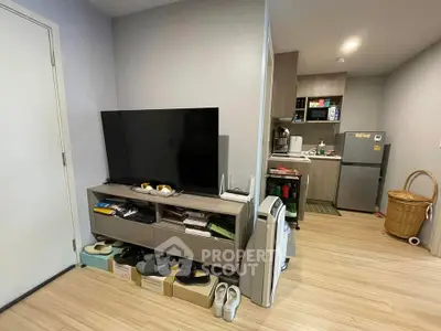 Modern apartment interior with compact kitchen and cozy living area, featuring sleek appliances and stylish decor.