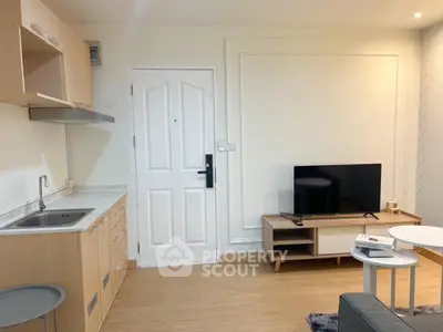 Modern living room with sleek TV stand and compact kitchen area